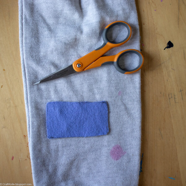 Cutting a patch from sweatshirt fabric.